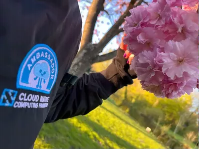Photo of CNCF Ambassadors logo on a black jacket with cherry blossoms in the background
